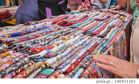 Vendor showing colorful pashminas at indian market Vendor showing colorful pashminas at indian market 140411301