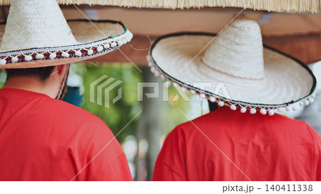 Two people wearing traditional Mexican sombreros and red shirts celebrating Cinco de Mayo Two people wearing traditional Mexican sombreros and red shirts celebrating Cinco de Mayo 140411338
