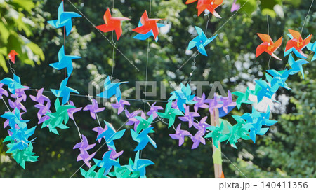 Colorful spinning pinwheels banner decorating an outdoor summer party celebration Colorful spinning pinwheels banner decorating an outdoor summer party celebration 140411356