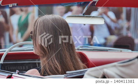 Woman driving red vintage convertible, cruising on road trip with freedom concept Woman driving red vintage convertible, cruising on road trip with freedom concept 140411381