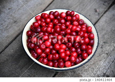 Cherry. Fresh sweet cherries bowl with leaves on wooden desktop table. water drops Fresh sour cherry berries Cherry. Fresh sweet cherries bowl with leaves on wooden desktop table. water drops Fresh sour cherry berries 140411464