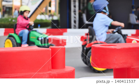 Child enjoying go-kart racing on outdoor track Child enjoying go-kart racing on outdoor track 140411537