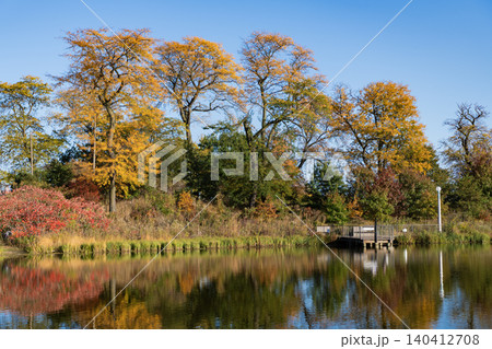 City park with water reflection lake. Autumn landscape nature. Park pond. Park in autumn with colorful fall trees. Autumn nature. Fall nature landscape. Lake in park with autumn tree 140412708