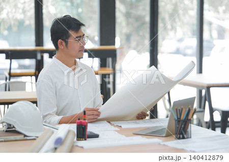 Engineer and Architect Reviewing Interior Design Plans with Laptop and Tools Engineer and Architect Reviewing Interior Design Plans with Laptop and Tools 140412879