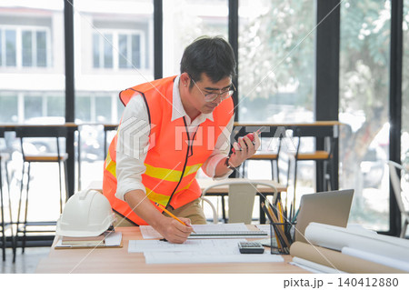 Engineer and Architect Reviewing Interior Design Plans in Office Engineer and Architect Reviewing Interior Design Plans in Office 140412880