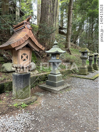 神社の参道に建つ伝統的な灯籠と森の風景 140415828