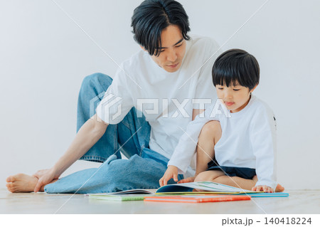父親と一緒に絵本を読む男の子 140418224