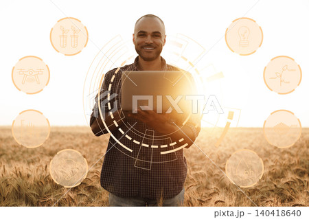 Smart farm technology at work in open field with farmer holding laptop during sunset Smart farm technology at work in open field with farmer holding laptop during sunset 140418640
