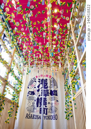 ピンクの天井から吊るされた伝統的なガラス風鈴と造花のひまわりによる鮮やかな夏の装飾。 ピンクの天井から吊るされた伝統的なガラス風鈴と造花のひまわりによる鮮やかな夏の装飾。 140418822