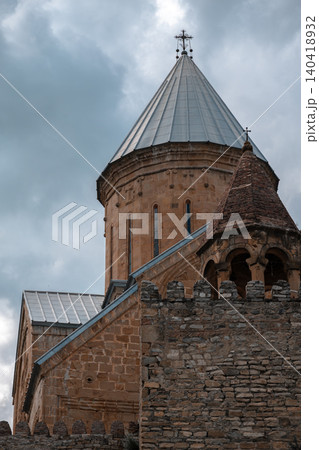 Low angle view of an ancient stone cathedral dome and fortified wall under dramatic clouds Low angle view of an ancient stone cathedral dome and fortified wall under dramatic clouds 140418932