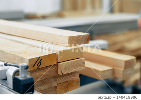 Wooden boards stacked in a furniture workshop during a busy workday 140418986