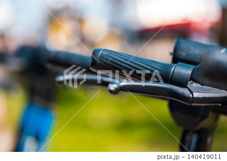 Detailed macro shot of black rubber grips and brake levers with a soft bokeh background Detailed macro shot of black rubber grips and brake levers with a soft bokeh background 140419011