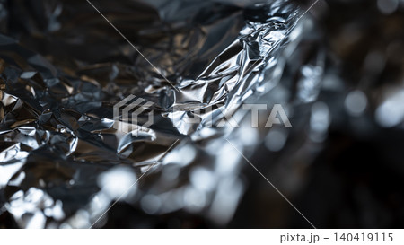 High contrast macro shot of crumpled silver foil showing metallic highlights and shadows High contrast macro shot of crumpled silver foil showing metallic highlights and shadows 140419115