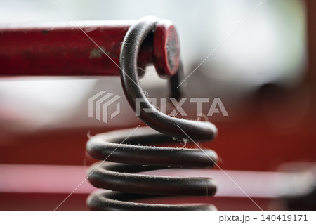 Detailed close-up of a black heavy-duty spring with bokeh background and sharp focus 140419171