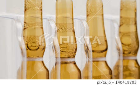 Macro shot of brown pharmaceutical ampoules with liquid vaccine and bubbles in a tray Macro shot of brown pharmaceutical ampoules with liquid vaccine and bubbles in a tray 140419203