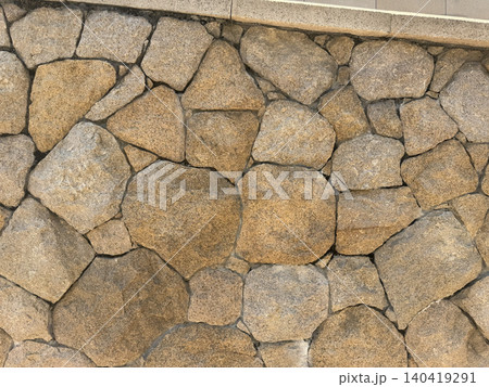 Natural stone wall texture with irregular shapes and warm earthy tones Natural stone wall texture with irregular shapes and warm earthy tones 140419291