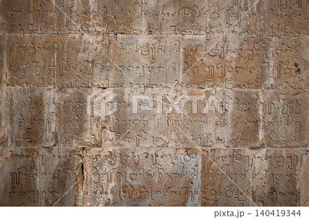 Detailed texture of historical Asomtavruli calligraphy engraved on aged sandstone blocks 140419344