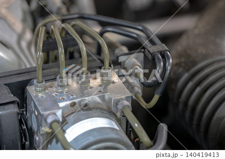Various pipes connect to an engine component in a vehicle's engine area. Various pipes connect to an engine component in a vehicle's engine area. 140419413