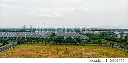 Row of houses with gray roofs and vast green land 140419451