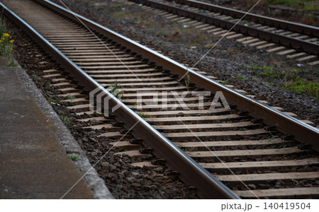Low angle shot of train tracks receding into the distance alongside a concrete platform 140419504
