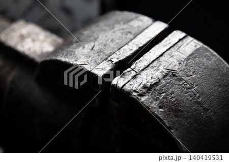 Macro shot of a heavy-duty industrial vise with dramatic lighting and gritty metallic texture 140419531