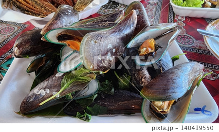 Fresh Steamed Green Mussels with Thai Basil on a White Plate Fresh Steamed Green Mussels with Thai Basil on a White Plate 140419550