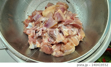 Fresh Raw Chopped Chicken Meat Pieces in a Stainless Steel Colander Fresh Raw Chopped Chicken Meat Pieces in a Stainless Steel Colander 140419552