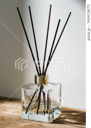 Decorative fragrance diffuser on wooden surface near wall in bright light Decorative fragrance diffuser on wooden surface near wall in bright light 140419672
