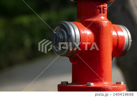 Vibrant red fire hydrant detail with metallic cap, soft bokeh background, and natural lighting Vibrant red fire hydrant detail with metallic cap, soft bokeh background, and natural lighting 140419698