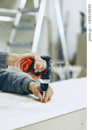 Creating furniture at a workshop with a power drill and wood 140419699
