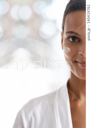 Portrait, skincare and closeup of woman with lotion for dermatology, wellness or beauty in morning. Smile, moisturizer and face of person for cosmetics facial treatment and healthy skin in house. 140419761
