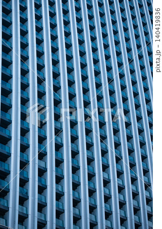 Tilted architectural shot showing rows of balconies and blue glass on a skyscraper Tilted architectural shot showing rows of balconies and blue glass on a skyscraper 140419836