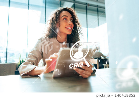 Woman using tablet to learn about customer relationship management in office during work hours Woman using tablet to learn about customer relationship management in office during work hours 140419852