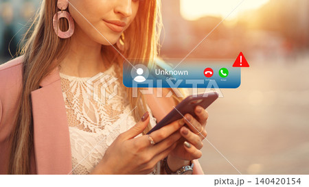 Scam call alert shows on smartphone while a woman looks at the screen in a public space 140420154