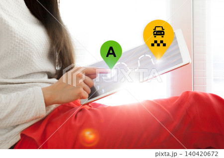 User checks travel route on a tablet for taxi service in a bright indoor setting User checks travel route on a tablet for taxi service in a bright indoor setting 140420672
