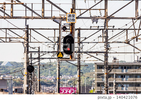 鉄道の信号機と速度切換標識 赤信号と複雑に入り組む架線柱 晴天の屋外 鉄道の信号機と速度切換標識 赤信号と複雑に入り組む架線柱 晴天の屋外 140421076