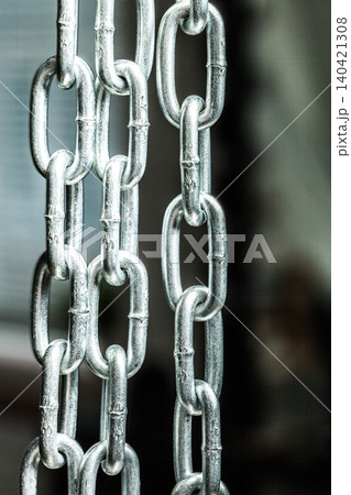 Close-up view of linked metal chains in an indoor setting with soft lighting 140421308