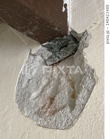 Severe wall damage with peeling plaster exposing inner structure close-up 140421489