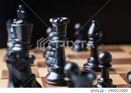 Black chess pieces on a wooden chessboard during a strategic game session Black chess pieces on a wooden chessboard during a strategic game session 140421800