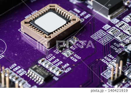 Close-up view of a purple circuit board with microchips and electronic components during assembly Close-up view of a purple circuit board with microchips and electronic components during assembly 140421919