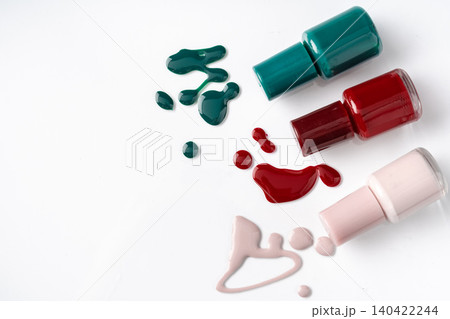Bright colored nail polish bottles with drippings on white background Bright colored nail polish bottles with drippings on white background 140422244
