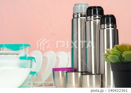 Thermos bottle against tableware in a kitchen Thermos bottle against tableware in a kitchen 140422361
