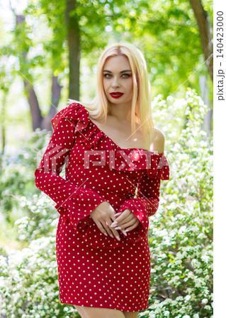 Blonde Woman in Red Polka Dot Dress in Green Forest Blonde Woman in Red Polka Dot Dress in Green Forest 140423000