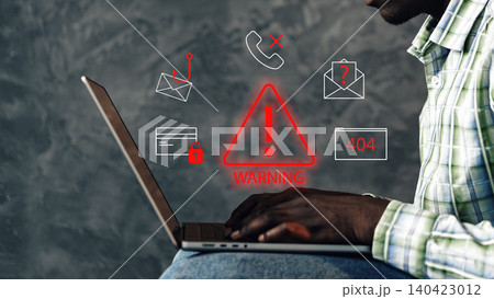 Scam call notification shows warning signs on laptop screen while a person types 140423012