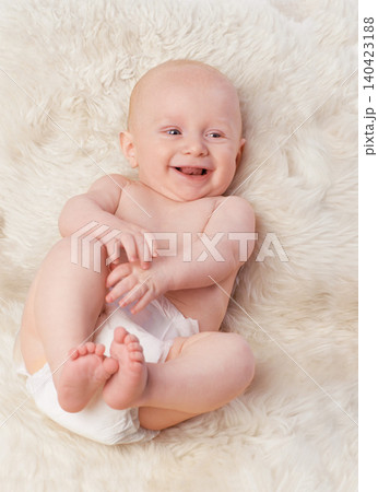 Baby, cute and laugh in bedroom, blanket and playtime in diaper for child development in happiness. Infant, kid and wellness for newborn, adorable and rug in house for home and toddler fun 140423188