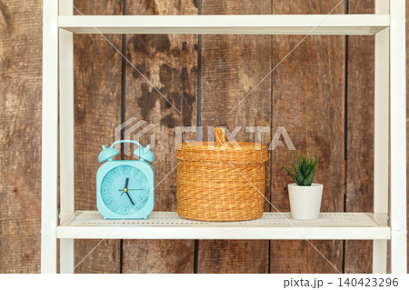 Close up of white bookshelf against grunge wooden wall Close up of white bookshelf against grunge wooden wall 140423296