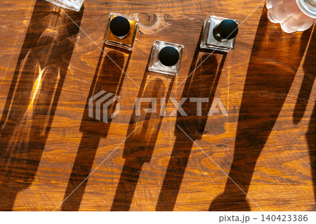 Set of perfume bottles on a bright light with shadows Set of perfume bottles on a bright light with shadows 140423386