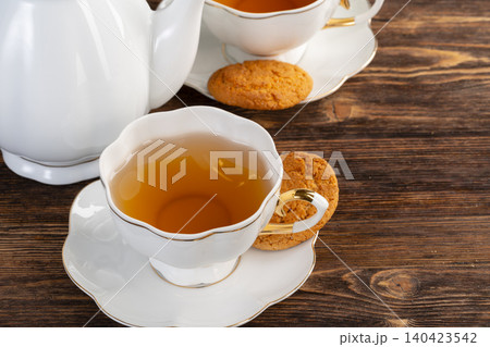 White porcelain cup of tea and oat cookies on a table White porcelain cup of tea and oat cookies on a table 140423542