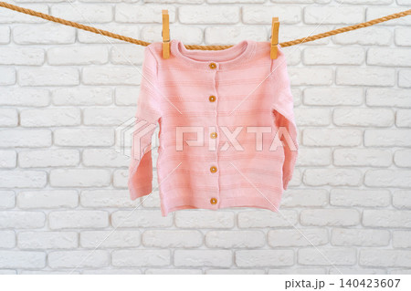 Washing of baby clothes pinned on a rope to dry Washing of baby clothes pinned on a rope to dry 140423607