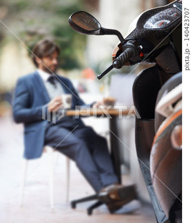 Scooter, city and businessman at outdoor restaurant for remote work on laptop or transport in morning. Travel, vehicle and street coffee shop with corporate person in suit working at sidewalk cafe Scooter, city and businessman at outdoor restaurant for remote work on laptop or transport in morning. Travel, vehicle and street coffee shop with corporate person in suit working at sidewalk cafe 140423707